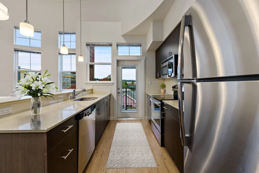 Kitchen with stainless steel refrigerator and island