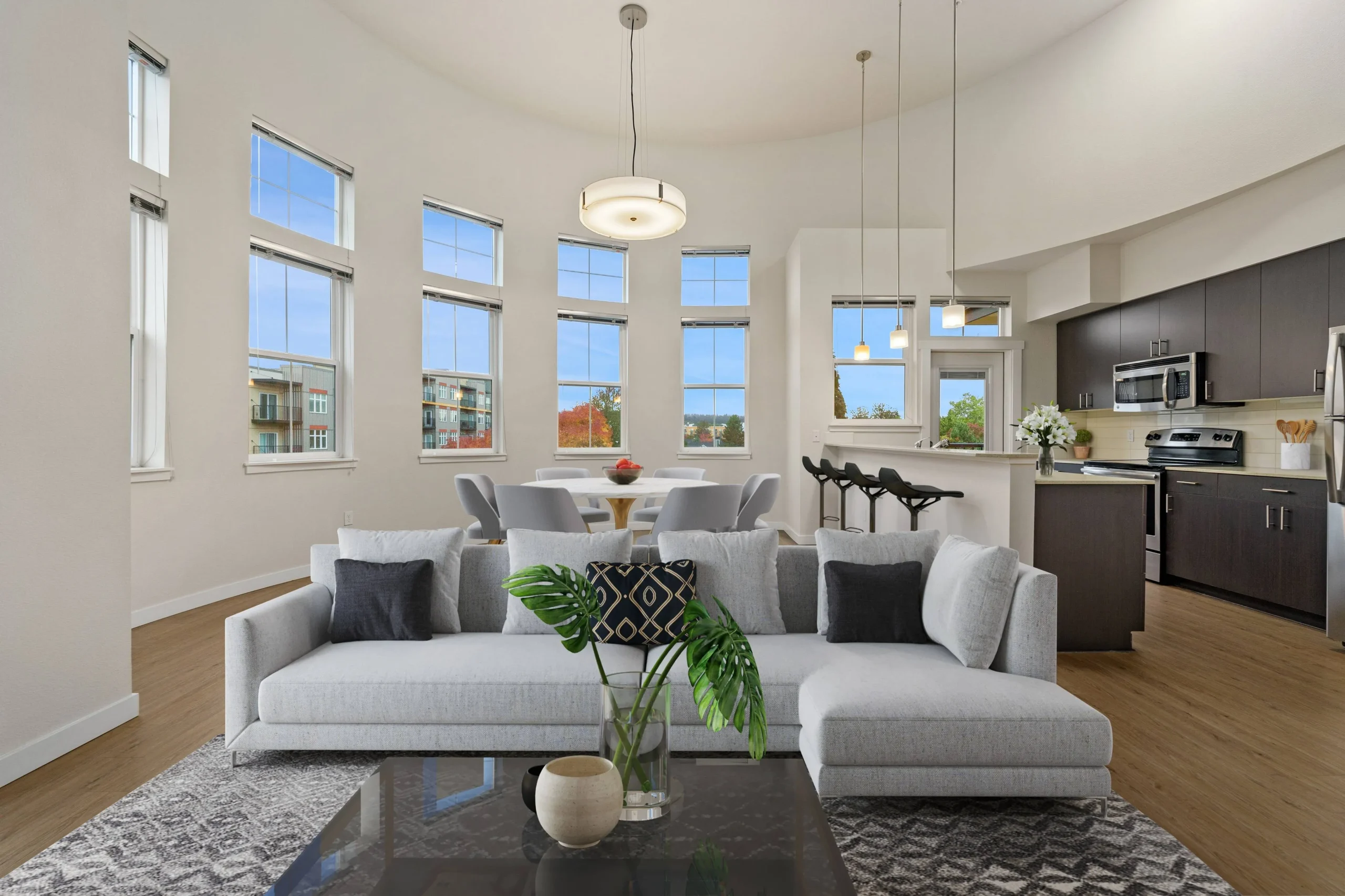 Open living room with sectional and kitchen behind